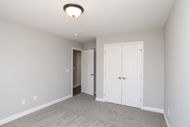 unfurnished bedroom with a closet and light colored carpet