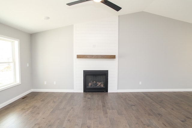 unfurnished living room featuring dark hardwood / wood-style flooring, ceiling fan, a healthy amount of sunlight, and vaulted ceiling