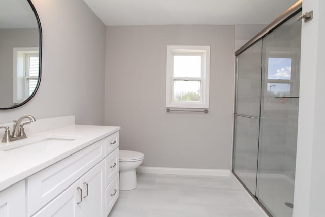 bathroom with walk in shower, toilet, and vanity