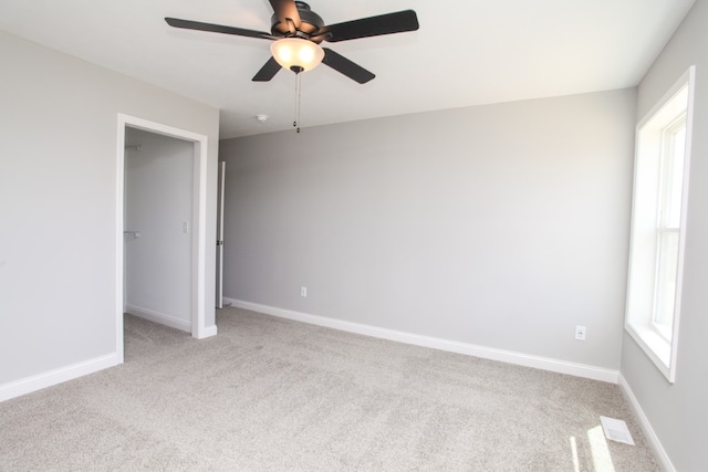 unfurnished bedroom with light carpet, multiple windows, and ceiling fan