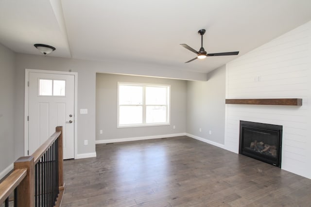 entrance foyer with ceiling fan, dark wood-type flooring, a fireplace, and vaulted ceiling