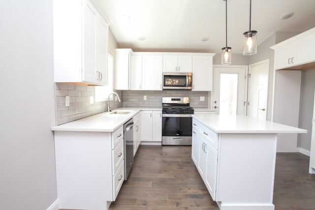 kitchen with dark hardwood / wood-style flooring, white cabinetry, sink, and stainless steel appliances