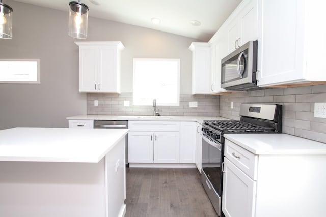 kitchen with white cabinets, vaulted ceiling, and stainless steel appliances