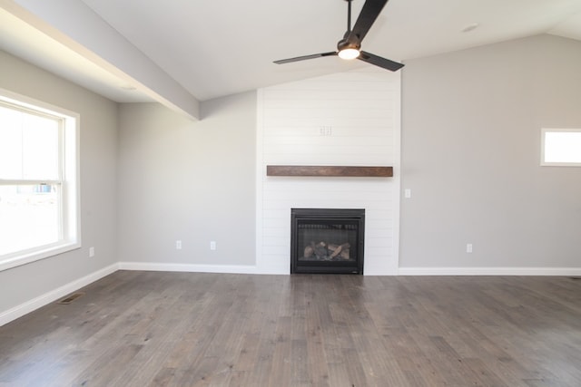 unfurnished living room with dark hardwood / wood-style flooring, brick wall, a fireplace, ceiling fan, and vaulted ceiling