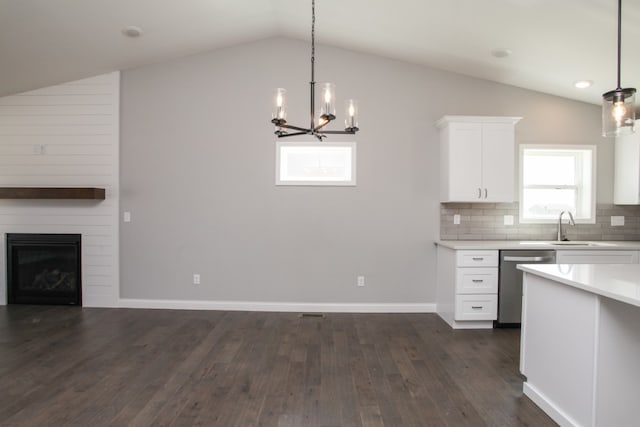 kitchen featuring decorative light fixtures, dark wood-type flooring, a notable chandelier, dishwasher, and tasteful backsplash