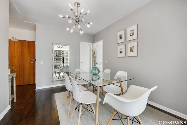 dining space with dark hardwood / wood-style flooring and an inviting chandelier