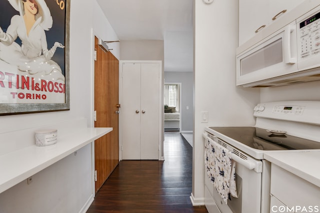 kitchen featuring white appliances, dark hardwood / wood-style floors, and white cabinetry