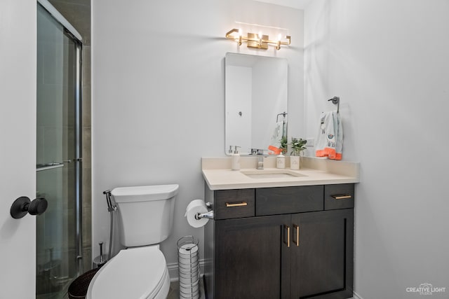 bathroom with toilet, an enclosed shower, and vanity with extensive cabinet space