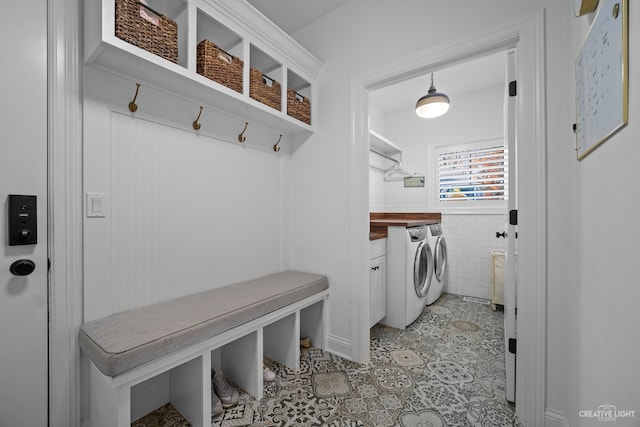 mudroom featuring light tile floors and washer and dryer