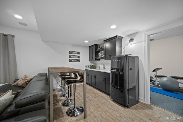 kitchen featuring sink, tasteful backsplash, and light hardwood / wood-style floors