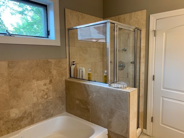 bathroom featuring independent shower and bath