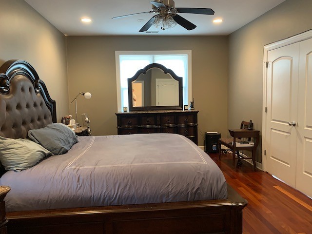 bedroom with dark hardwood / wood-style floors and ceiling fan