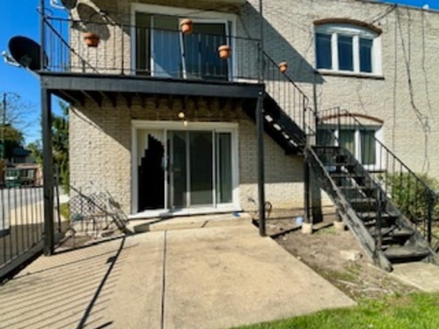 back of property featuring a balcony and a patio