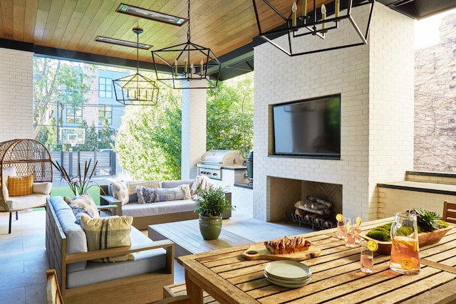 exterior space with an outdoor brick fireplace, wood ceiling, and a chandelier