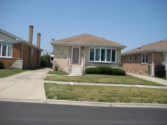 bungalow-style house with brick siding and a front yard