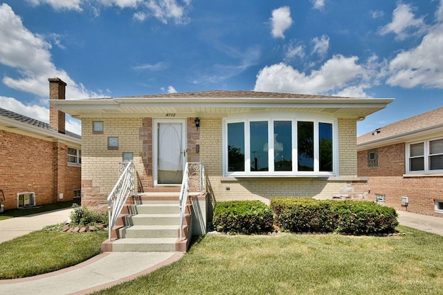 view of front of property featuring brick siding and a front lawn