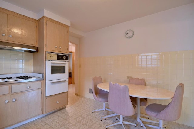 dining room featuring tile walls and wainscoting