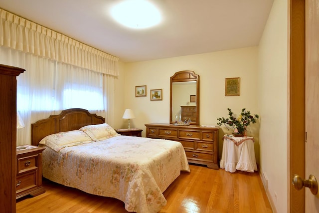 bedroom with light wood-style flooring and baseboards