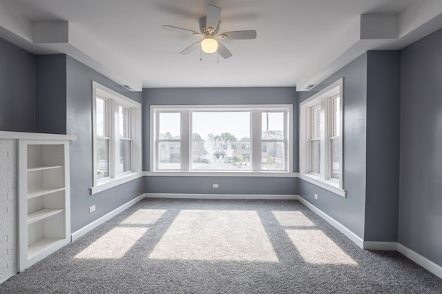 carpeted spare room featuring ceiling fan