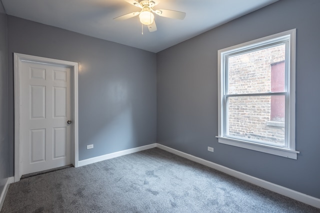 carpeted spare room featuring ceiling fan and a healthy amount of sunlight