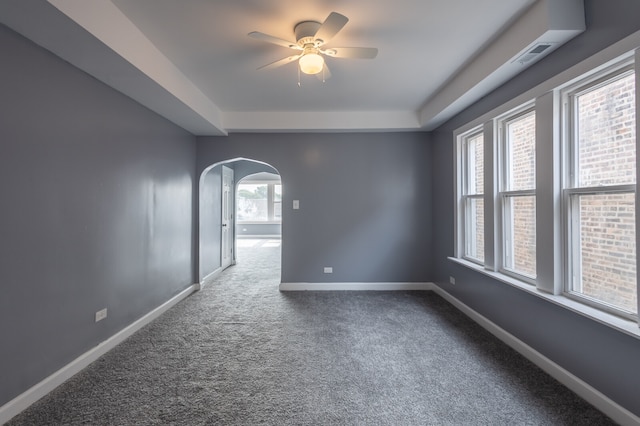 carpeted empty room featuring ceiling fan and a tray ceiling