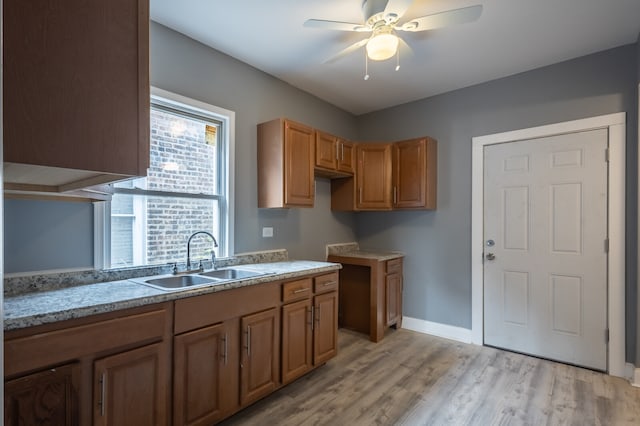 kitchen featuring ceiling fan, sink, and light hardwood / wood-style floors