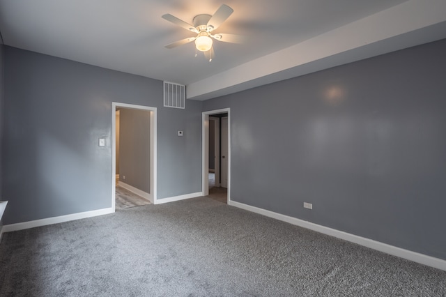 spare room with ceiling fan and dark colored carpet