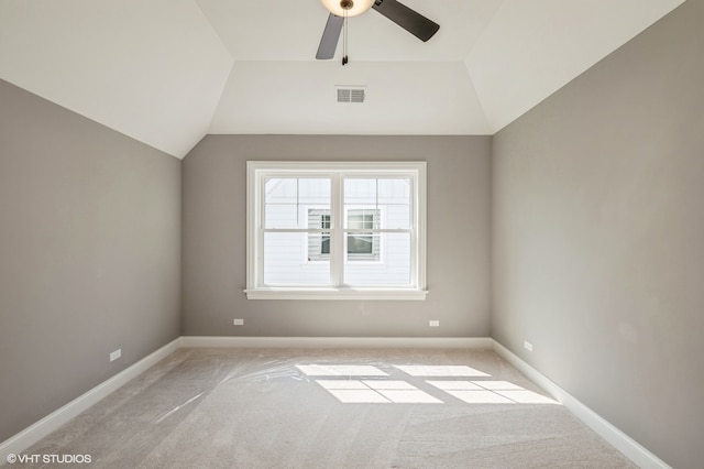 carpeted empty room with ceiling fan and lofted ceiling