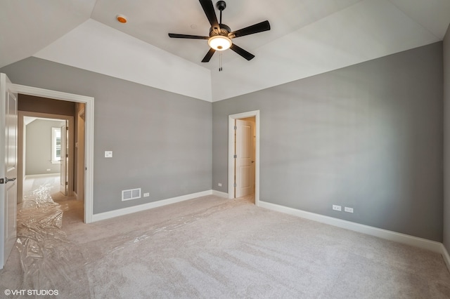 empty room with light colored carpet, lofted ceiling, and ceiling fan