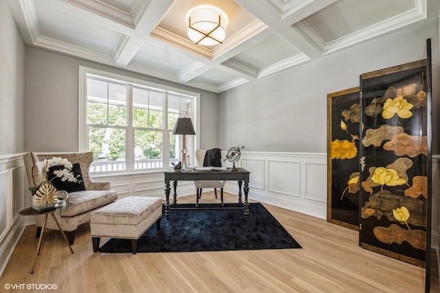 sitting room with beam ceiling, light hardwood / wood-style floors, ornamental molding, and coffered ceiling