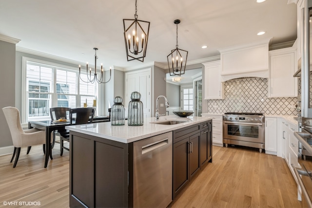 kitchen featuring sink, custom range hood, light hardwood / wood-style floors, tasteful backsplash, and stainless steel appliances