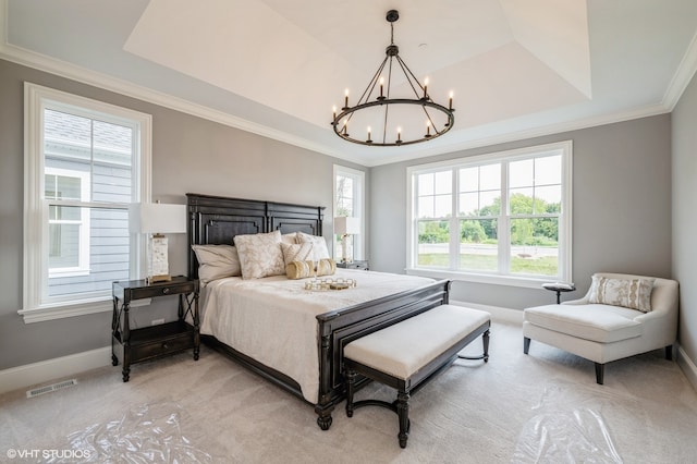 bedroom featuring light carpet, crown molding, an inviting chandelier, and a tray ceiling