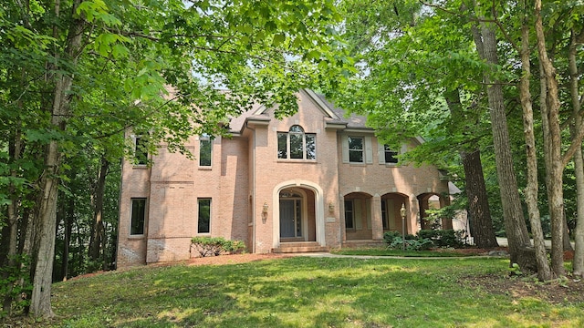 view of front of house featuring brick siding and a front lawn