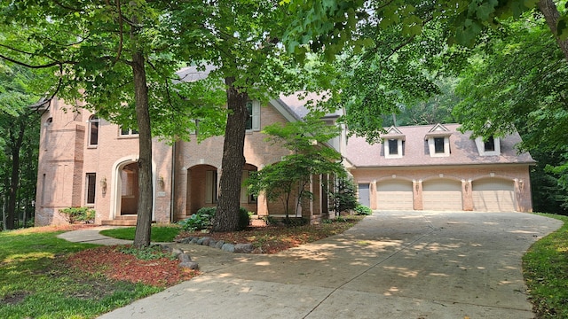 view of front of property with driveway, a garage, and brick siding