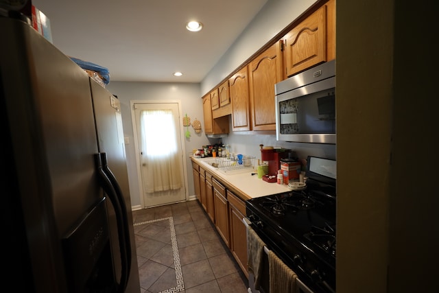 kitchen featuring electric range oven, black refrigerator, and dark tile flooring