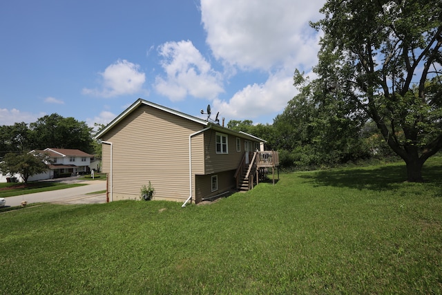 view of side of property with a yard and a wooden deck