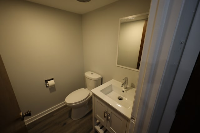 bathroom featuring toilet, vanity, and wood-type flooring