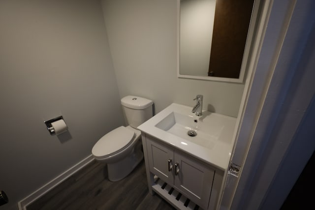 bathroom with toilet, oversized vanity, and wood-type flooring