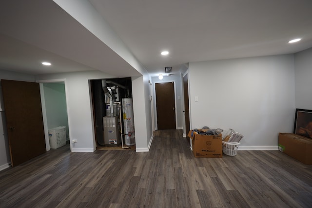 interior space with water heater, dark hardwood / wood-style floors, and heating utilities