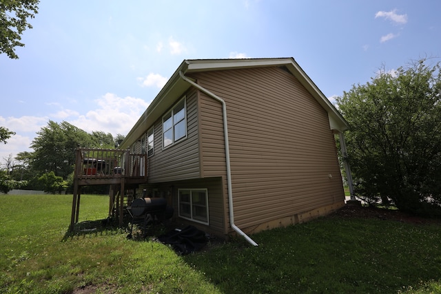 view of side of property featuring a deck and a lawn