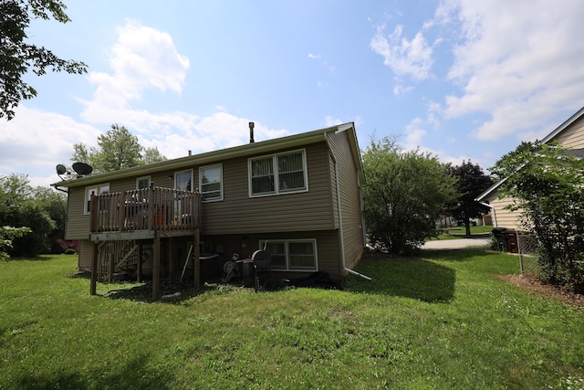 rear view of house with a wooden deck and a yard