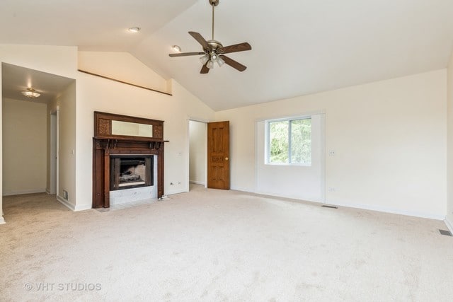 unfurnished living room with high vaulted ceiling, light colored carpet, and ceiling fan