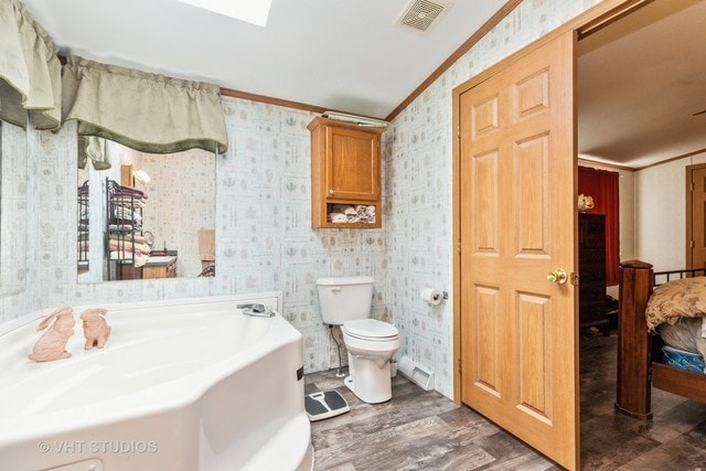 bathroom with toilet, hardwood / wood-style flooring, and crown molding