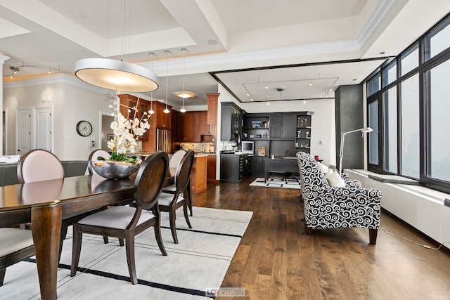 dining room with a raised ceiling, ceiling fan, ornamental molding, and dark wood-type flooring