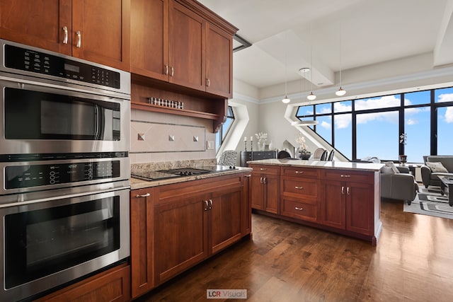 kitchen with dark wood-type flooring, light stone counters, beamed ceiling, double oven, and backsplash