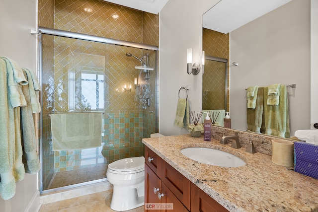 bathroom with toilet, a shower with door, vanity with extensive cabinet space, and tile flooring