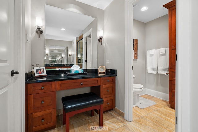 bathroom featuring tile flooring, vanity with extensive cabinet space, and toilet