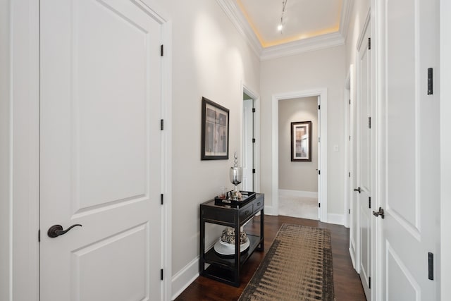 hall featuring crown molding, dark hardwood / wood-style floors, and rail lighting