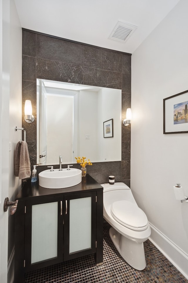 bathroom with tile flooring, toilet, tile walls, and oversized vanity