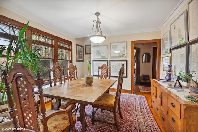 dining space with hardwood / wood-style flooring and ornamental molding